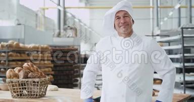 在一个<strong>大</strong>的面包店里，一个漂亮的成熟男人面包师，笑得<strong>很大</strong>，在镜头前表现出<strong>很大</strong>的样子